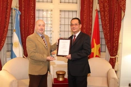 Đại sứ Nguyễn Đình Thao trao giải thưởng cho ông Horacio Raña. (Ảnh: Diệu Hương/Vietnam+)