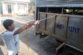 Lực lượng chức năng phun xịt khử trùng xe vận chuyển động vật trước khi vận chuyển vào địa bàn tỉnh Bà Rịa-Vũng Tàu. (Ảnh: Hoàng Nhị/TTXVN)