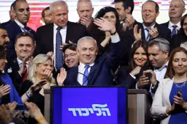 Thủ tướng Israel Benjamin Netanyahu (giữa) vẫy chào những người ủng hộ sau khi kết quả bầu cử được công bố, tại trụ sở đảng Likud ở Tel Aviv, ngày 10/4. (Ảnh: AFP/TTXVN)