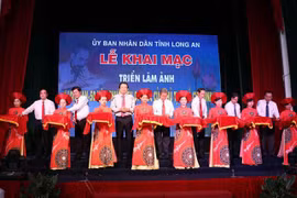 Lãnh đạo tỉnh Long An cùng các đại biểu cắt băng khai mạc triển lãm ảnh. (Ảnh: Bùi Giang/TTXVN)