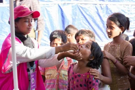 Một nữ tình nguyện viên nhân đạo cho trẻ uống thuốc. (Nguồn: blog.brac.net)