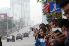 Người dân đứng trên phố Trần Duy Hưng đón đoàn xe của Tổng thống Mỹ Donald Trump đi qua. (Ảnh: Huy Hùng/TTXVN)