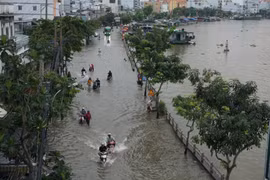 Nước ngập sâu trên đường Trần Xuân Soạn, quận 7, gây khó khăn trong việc đi lại và sinh hoạt của người dân. (Ảnh: Trần Xuân Tình/TTXVN)