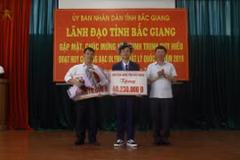 Phó Chủ tịch Lê Ánh Dương trao Bằng khen của Chủ tịch Ủy ban Nhân dân tỉnh và phần thưởng hơn 40,2 triệu đồng cho em Trịnh Duy Hiếu. (Ảnh: Tùng Lâm/TTXVN)