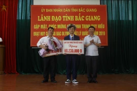 Phó Chủ tịch Lê Ánh Dương trao Bằng khen của Chủ tịch Ủy ban Nhân dân tỉnh và phần thưởng hơn 40,2 triệu đồng cho em Trịnh Duy Hiếu. (Ảnh: Tùng Lâm/TTXVN)
