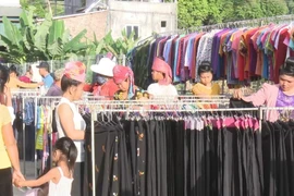 Người dân lựa chọn đồ may mặc hàng Việt Nam. (Ảnh minh họa: Nguyễn Cường/TTXVN)
