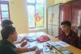 Đối tượng Lầu A Câu cùng tang vật tại cơ quan điều tra. (Ảnh: TTXVN)