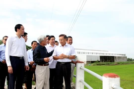 Ông Saysomphone Phomvihane (bên phải) tìm hiểu về mô hình cánh đồng lớn tại huyện Cờ Đỏ, thành phố Cần Thơ. (Ảnh: TTXVN)