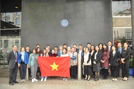 Cán bộ, nhân viên Đại sứ quán, các cơ quan đại diện Việt Nam, học sinh, sinh viên cùng đại diện bà con Việt kiều tại Anh chụp ảnh kỷ niệm dưới Biển tưởng niệm Bác Hồ tại Tòa nhà New Zealand. (Ảnh: Đình Thư/Vietnam+)