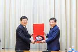 Chủ tịch UBND Thành phố Hồ Chí Minh Nguyễn Thành Phong trao quà lưu niệm cho ông Từ Lạc Giang. (Ảnh: Xuân Khu/TTXVN)