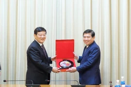 Chủ tịch UBND Thành phố Hồ Chí Minh Nguyễn Thành Phong trao quà lưu niệm cho ông Từ Lạc Giang. (Ảnh: Xuân Khu/TTXVN)