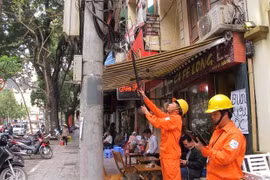 Nhân viên ngành điện đang chốt chỉ số công tơ của khách hàng. (Ảnh: Đức Duy/Vietnam+)