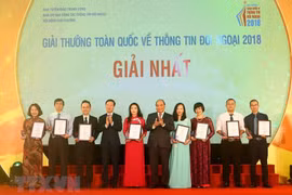 Thủ tướng Nguyễn Xuân Phúc và ông Võ Văn Thưởng, Uỷ viên Bộ Chính trị, Bí thư Trung ương Đảng, Trưởng ban Tuyên giáo Trung ương trao giải Nhất cho các tác giả. (Ảnh: Doãn Tấn/TTXVN)