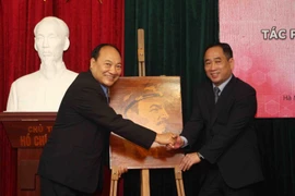 Ông Nguyễn Anh Minh (bên phải), Giám đốc Bảo tàng Mỹ thuật Việt Nam bàn giao tác phẩm 'Chân dung Lenin' cho đại diện bảo tàng Kaysone Phomvihane. (Ảnh: Thanh Tùng/TTXVN)
