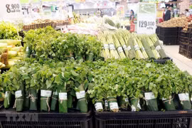 Nhiều kênh phân phối hiện đại đã từng bước sử dụng lá chuối tươi gói thực phẩm, nông sản. (Ảnh: Mỹ Phương/TTXVN)
