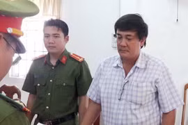 Lực lượng chức năng đọc lệnh bắt giam giam bị can Đỗ Minh Thống. (Ảnh: Thế Anh/TTXVN)