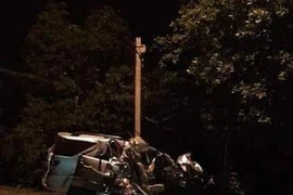 Tại hiện trường, xe du lịch 7 chỗ ngồi bẹp rúm sau vụ va chạm. (Ảnh: TTXVN)