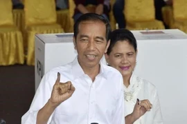 Tổng thống Indonesia Joko Widodo và phu nhân bỏ phiếu tại một địa điểm bầu cử ở Jakarta ngày 17/4. (Ảnh: Kyodo/TTXVN)