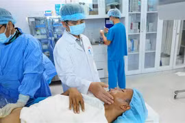 Bác sỹ thăm khám cho bệnh nhân sau can thiệp. (Ảnh: TTXVN)