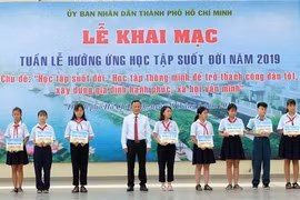Các em học sinh được nhận học bổng khuyến học tại chương trình. (Ảnh: Thu Hoài/TTXVN)