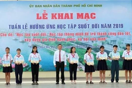 Các em học sinh được nhận học bổng khuyến học tại chương trình. (Ảnh: Thu Hoài/TTXVN)