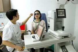 Các bác sỹ Bệnh viện Mắt Hà Nội 2 khám, tư vấn cho người bệnh. (Ảnh: Dương Ngọc/TTXVN)