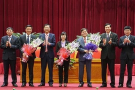 Bí thư Tỉnh ủy Quảng Ninh Nguyễn Văn Đọc tặng hoa chúc mừng các đồng được bầu giữ chức danh Phó Chủ tịch Hội đồng Nhân dân và Ủy ban Nhân dân tỉnh. (Ảnh: Văn Đức/TTXVN)