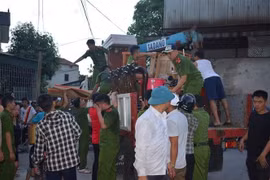 Lực lượng chức năng giúp di dời 80 hộ dân của huyện Nghi Sơn ra khỏi vùng nguy hiểm (Ảnh: TTXVN)