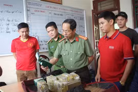 Lực lượng chức năng Công an tỉnh Hòa Bình kiểm tra và xác minh tang vật thu giữ được của 4 đối tượng. (Ảnh: Vũ Hà/TTXVN)