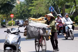 Người thu mua phế liệu mưu sinh giữa trời nắng gay gắt. (Ảnh: Danh Lam/TTXVN)
