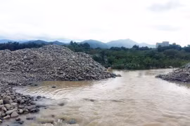 Nhiều đống đá lớn đã được doanh nghiệp khai thác, tập kết đã cản trở dòng chảy của sông Dinh. (Ảnh: Công Thử/TTXVN)