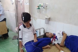 Các em học sinh được điều trị tại Bệnh viện đa khoa huyện Trần Văn Thời. (Ảnh: Huỳnh Thế Anh/TTXVN)