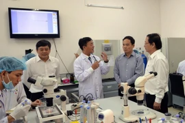 Phó Bí thư Thường trực Thành ủy Thành phố Hồ Chí Minh Trần Lưu Quang thăm phòng thí nghiệm Đại học Quốc gia Thành phố Hồ Chí Minh. (Ảnh: Thu Hoài/TTXVN)