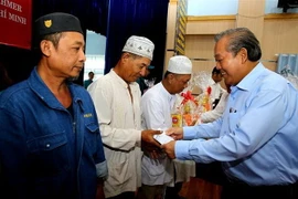 Phó Thủ tướng Trương Hòa Bình trao quà cho đồng bào dân tộc Chăm ở Thành phố Hồ Chí Minh. (Ảnh: Thành Chung/TTXVN)