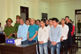 Các bị cáo đứng trước vành móng ngựa chờ nghe tuyên án. (Ảnh: Thanh Tân/TTXVN)