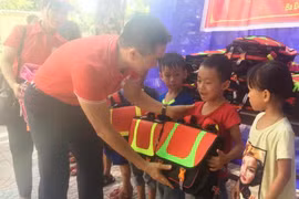 Phó Chủ tịch Trung ương Hội Chữ thập Đỏ Việt Nam Nguyễn Hải Anh trao tặng cặp phao cho các em học sinh trưởng Tiểu học Quảng Hải, thị xã Ba Đồn, tỉnh Quảng Bình. (Ảnh: Võ Dung/TTXVN)