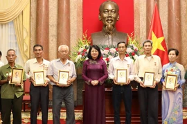 Phó Chủ tịch nước Đặng Thị Ngọc Thịnh trao ảnh Chủ tịch Hồ Chí Minh tặng các đại biểu thương binh, gia đình liệt sỹ, người có công với cách mạng tỉnh Cà Mau. (Ảnh: Lâm Khánh/TTXVN)