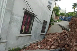 Phần móng một ngôi nhà bị sụt, nghiêng. (Ảnh: Mạnh Khánh/TTXVN)