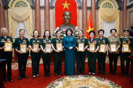 Phó Chủ tịch nước Đặng Thị Ngọc Thịnh tặng chân dung Chủ tịch Hồ Chí Minh cho các đại biểu nữ bộ đội Trường Sơn, thanh niên xung phong, dân quân hỏa tuyến, công nhân giao thông thời kỳ kháng chiến. (Ảnh: Lâm Khánh – TTXVN)