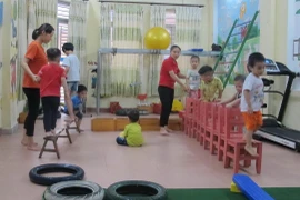 Giáo viên can thiệp, trị liệu và hỗ trợ hòa nhập cho trẻ ở Trung tâm. (Ảnh: Thùy Dung/TTXVN)