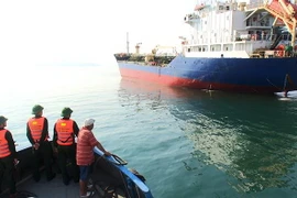 Tàu của Đồn Biên phòng cửa khẩu cảng Chân Mây tiếp cận tàu chở thuyền viên bị nạn. (Ảnh Hồ Cầu/TTXVN)