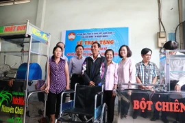 Ban vận động vì người nghèo quận 11 trao tặng phương tiện sinh kế cho hộ nghèo, hộ cận nghèo tại địa phương. (Ảnh: Đinh Hằng/TTXVN)