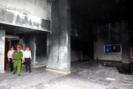 Lực lượng chức năng tiến hành điều tra nguyên nhân vụ cháy tại chung cư Carina Plaza, Thành phố Hồ Chí Minh. (Ảnh: Thanh Vũ/TTXVN)