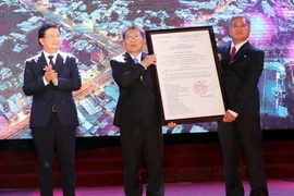 Phó Thủ tướng Trịnh Đình Dũng trao Quyết định của Thủ tướng Chính phủ công nhận thành phố Bến Tre là đô thị loại II trực thuộc tỉnh Bến Tre. (Ảnh: Trọng Đức/TTXVN)