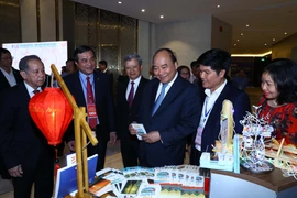 Thủ tướng Nguyễn Xuân Phúc và các đại biểu thăm các gian hàng trưng bày tại hội nghị. 