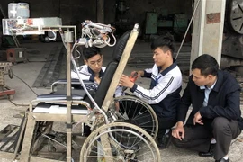 Hùng và Tân đang nghiên cứu thêm tính năng cho sản phẩm. (Ảnh: Hải Yến/TTXVN)