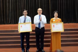 Bí thư Thành ủy Thành phố Hồ Chí Minh Nguyễn Thiện Nhân chúc mừng 2 tập thể có thành tích xuất sắc trong công tác giáo dục và đào tạo được nhận Huân chương Lao động hạng Ba. (Ảnh: Thu Hoài/TTXVN)