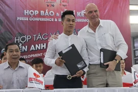 Đại diện Hội đồng quyền Anh Việt Nam và võ sỹ Trần Văn Thảo ký kết phối hợp và hỗ trợ tập luyện để tham gia trận tranh đai vô địch thế giới. (Ảnh: Xuân Dự/TTXVN)