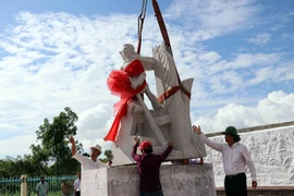 Thực hiện nghi thức đặt tượng đài kỷ niệm ngành giao bưu và vô tuyến điện Nam Bộ tại buổi lễ. (Ảnh: Kim Há/TTXVN)