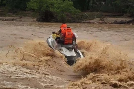 Lực lượng chức năng vượt sông mang nhu yếu phẩm vào với đồng bào bản Sa Ná. (Ảnh: Trịnh Duy Hưng/TTXVN)